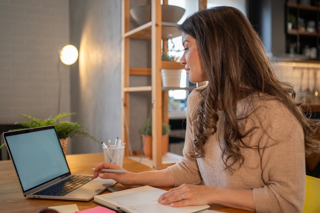 Kvinne peker på finansielle grafer på storskjerm mens hun vurderer verktøy som gratis regnskapsprogram for bedriften sin.